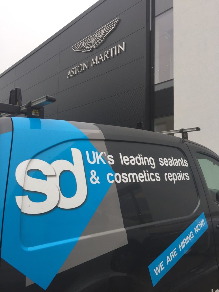 sd van outside the aston martin garage