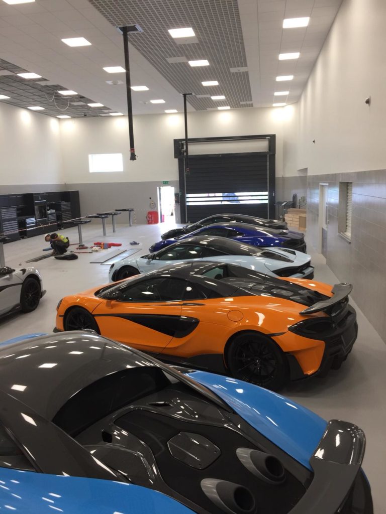 vier supercars naast elkaar in een showroom